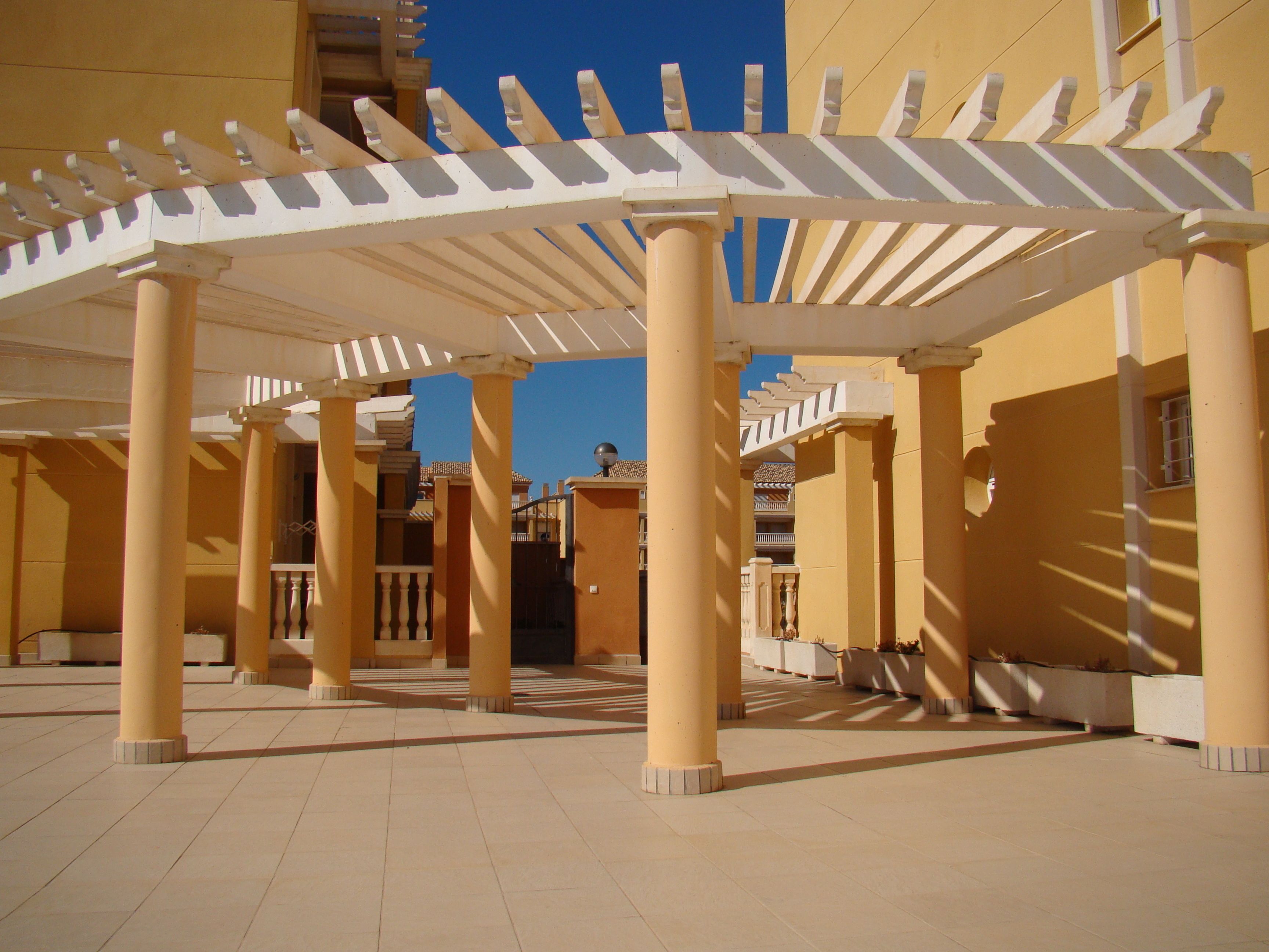 A covered outdoor area with columns and a pergola structure.
