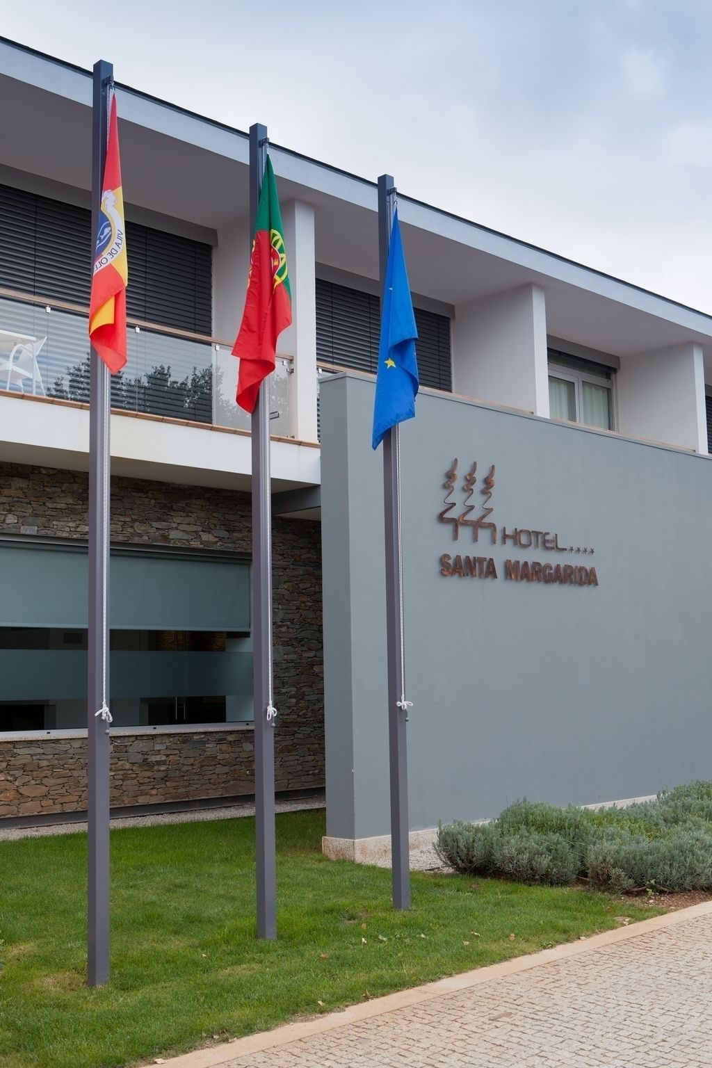 A hotel sign with flags, indicating multiple nationalities.