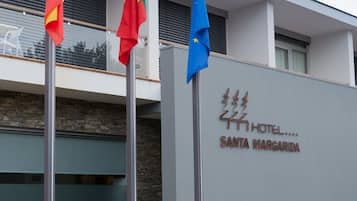 A hotel sign with flags, indicating multiple nationalities.