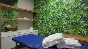 Guest rooms offer a calming atmosphere with a soothing leafy patterned wall and a convenient examination table.