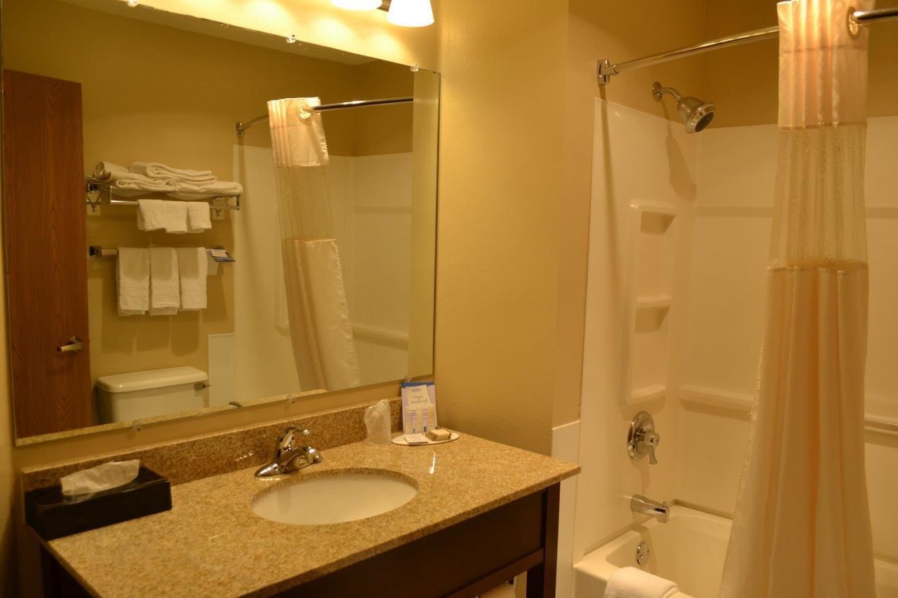 Un baño con lavamanos, espejo y ducha.