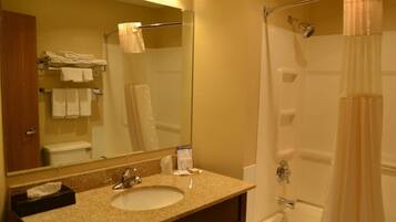 Un baño con lavamanos, espejo y ducha.