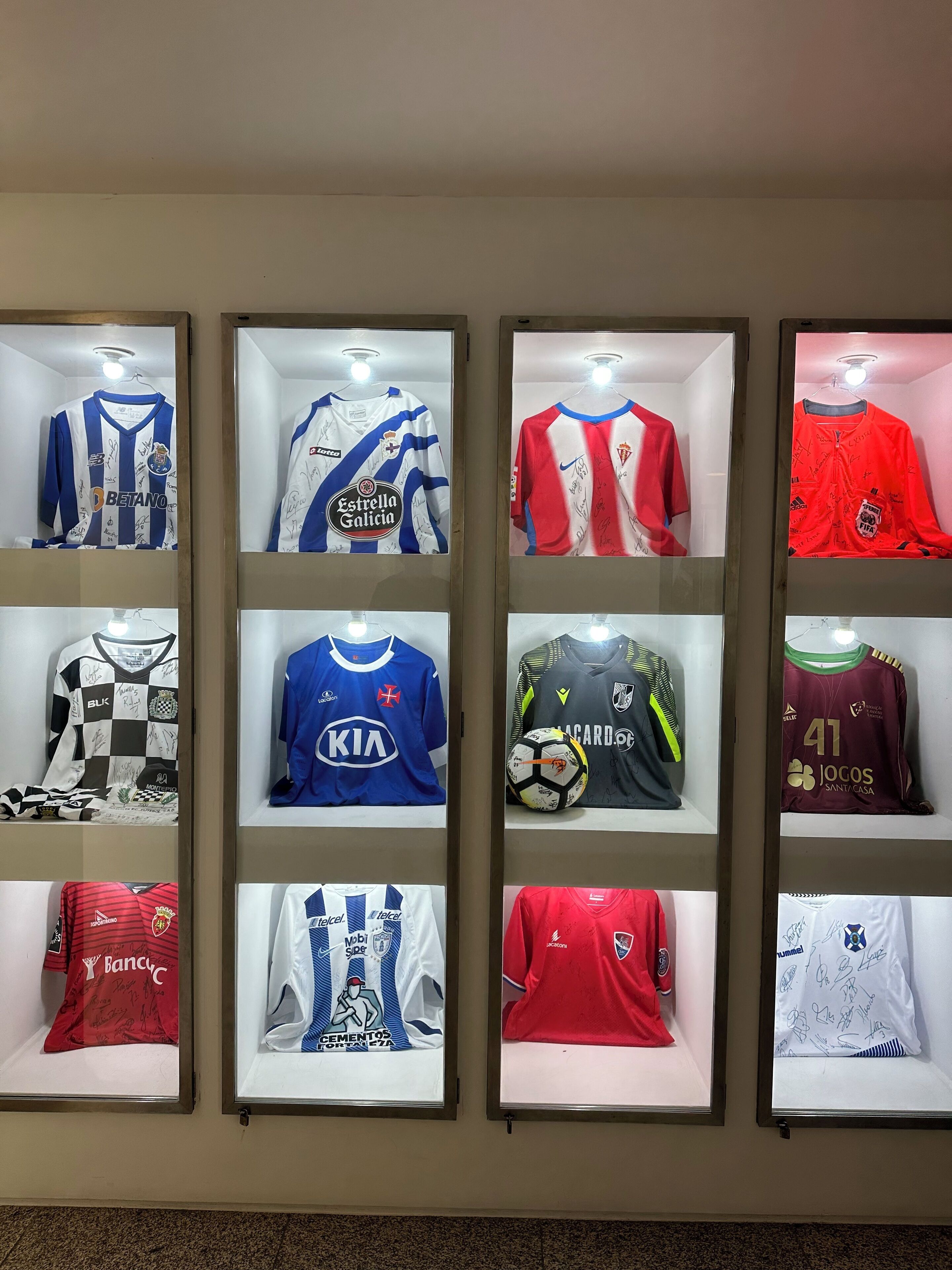 A display of signed sports jerseys in glass cases.