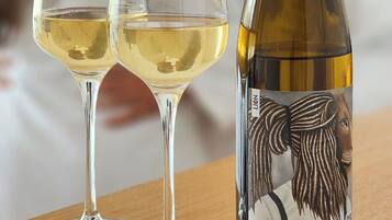 Two wine glasses and a bottle of wine on a wooden table.