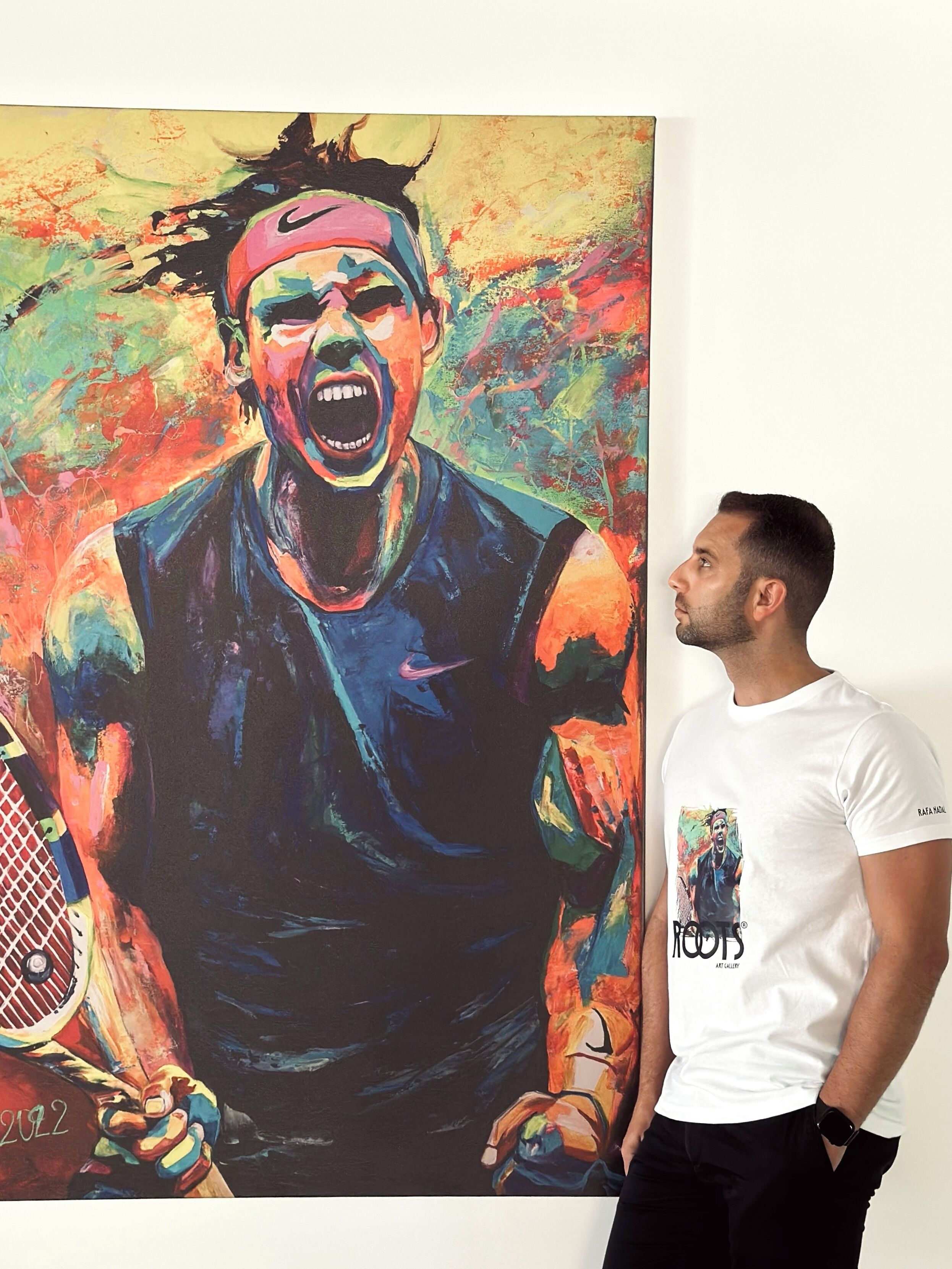 A person standing next to a large colorful painting.