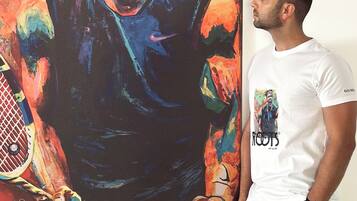 A person standing next to a large colorful painting.