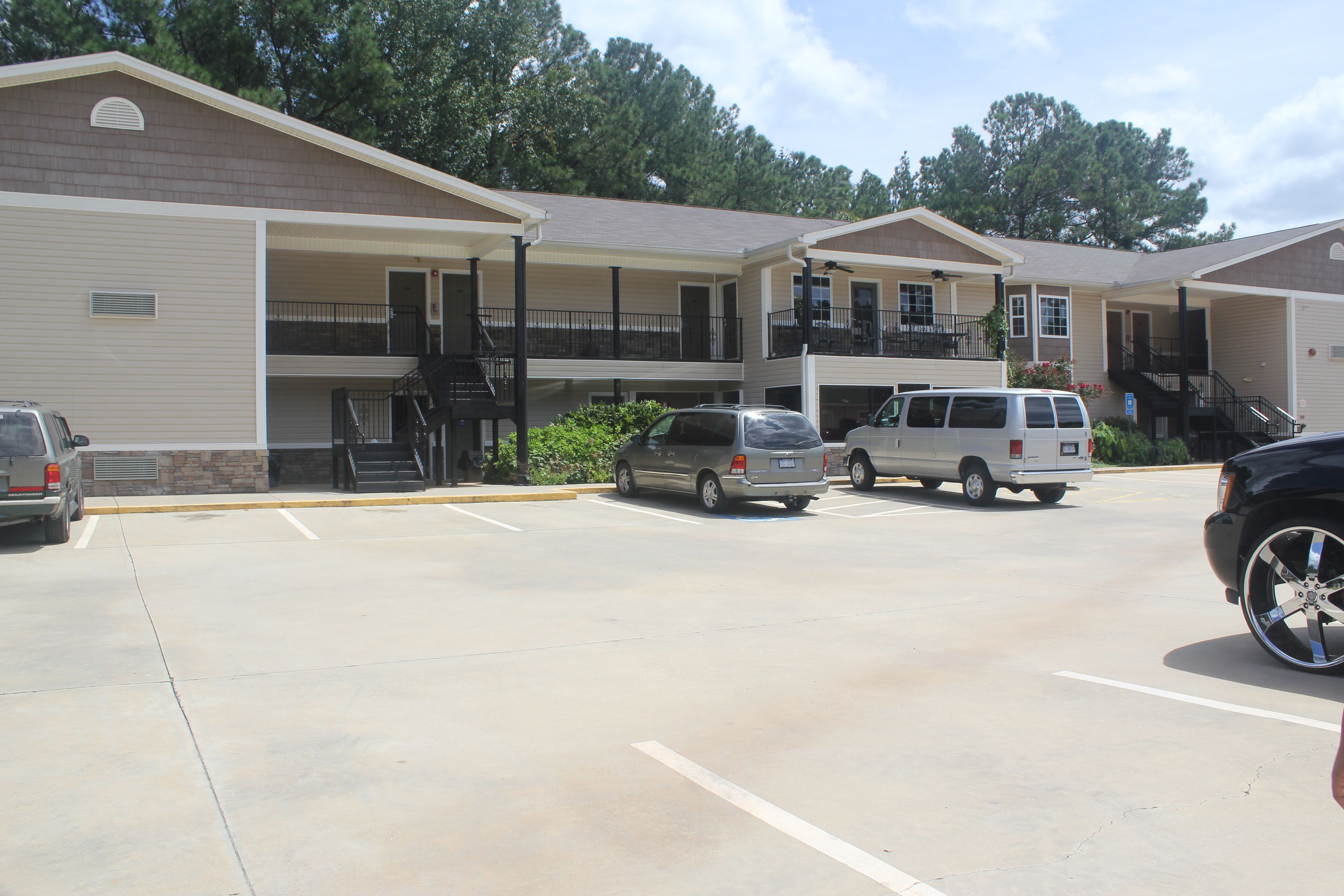A motel with multiple floors, outdoor parking, and a covered walkway.