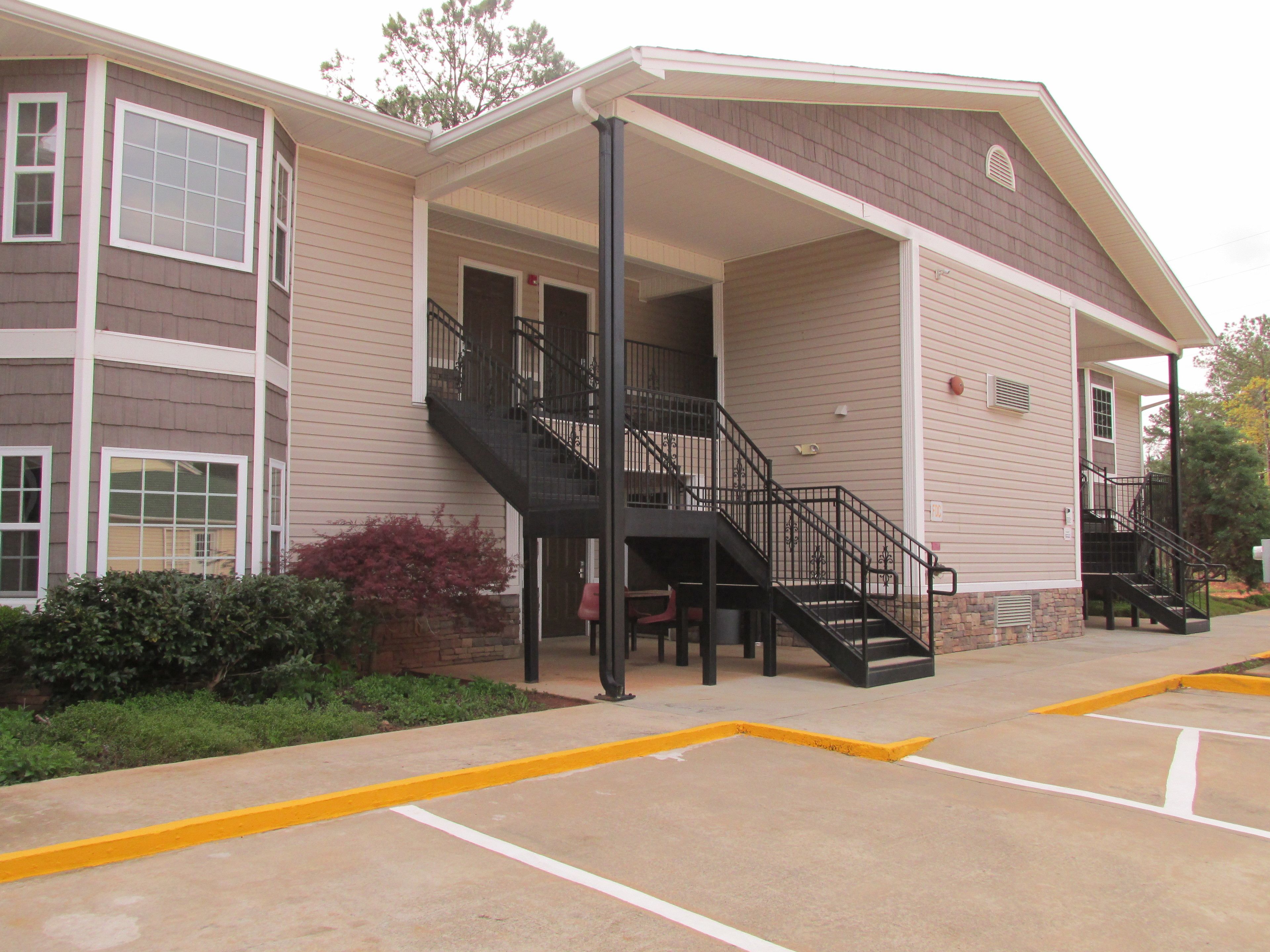 A multi-story building with a covered entrance and a staircase.