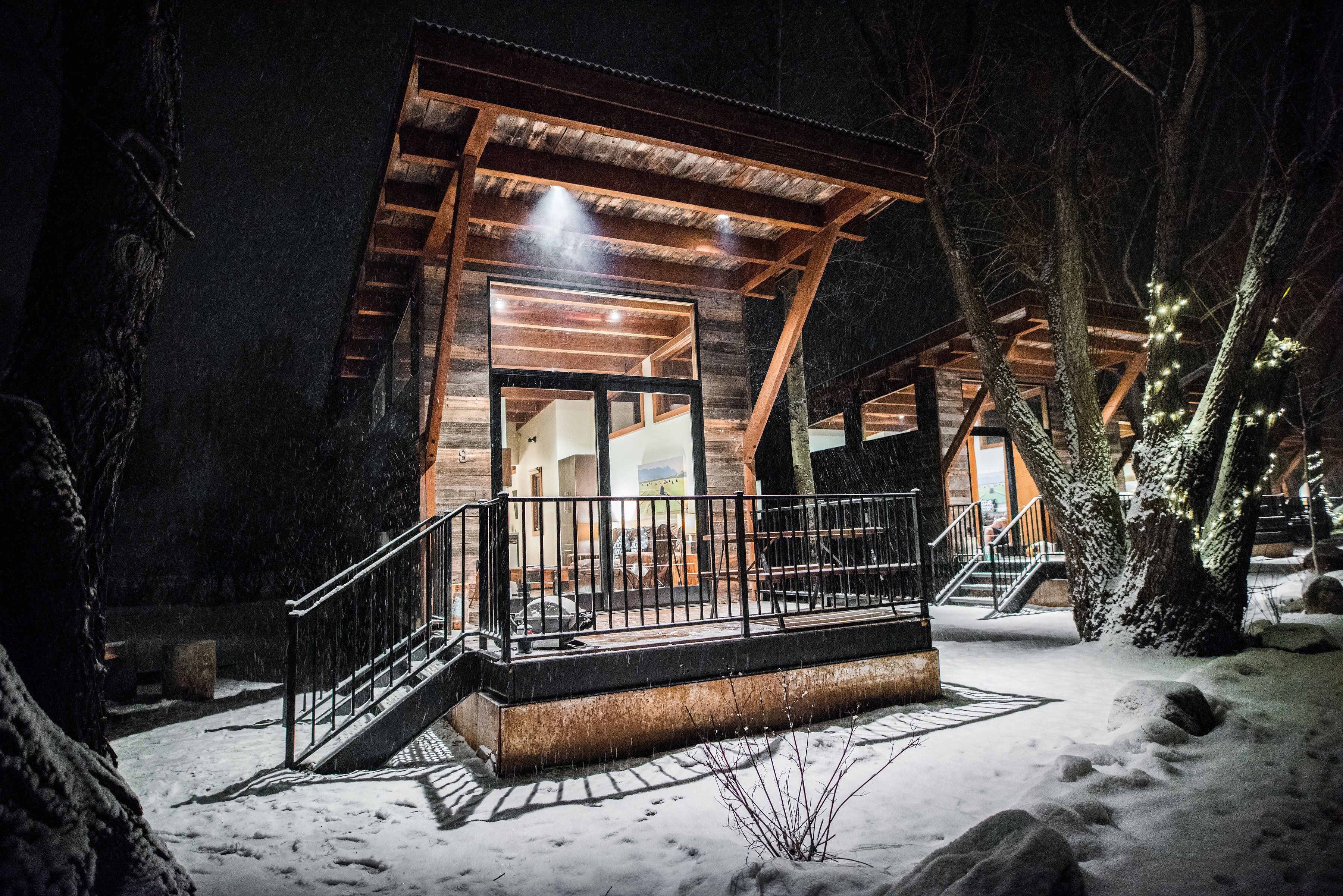 A wooden cabin with a balcony and a staircase leading to the entrance.