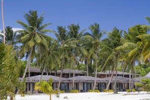 A beachfront resort with thatched-roof huts, palm trees, and a sandy beach. - Return to Paradise Resort and Spa (Matautu)