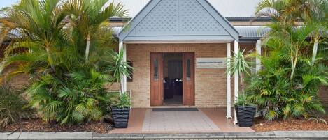 A building with a brick facade, a tiled entrance, and a sign reading "Conference & Function Centre".