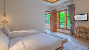 Habitación de hotel con dos camas, un escritorio, una silla y un televisor que muestra el logotipo de Swiss-Bellvillas.