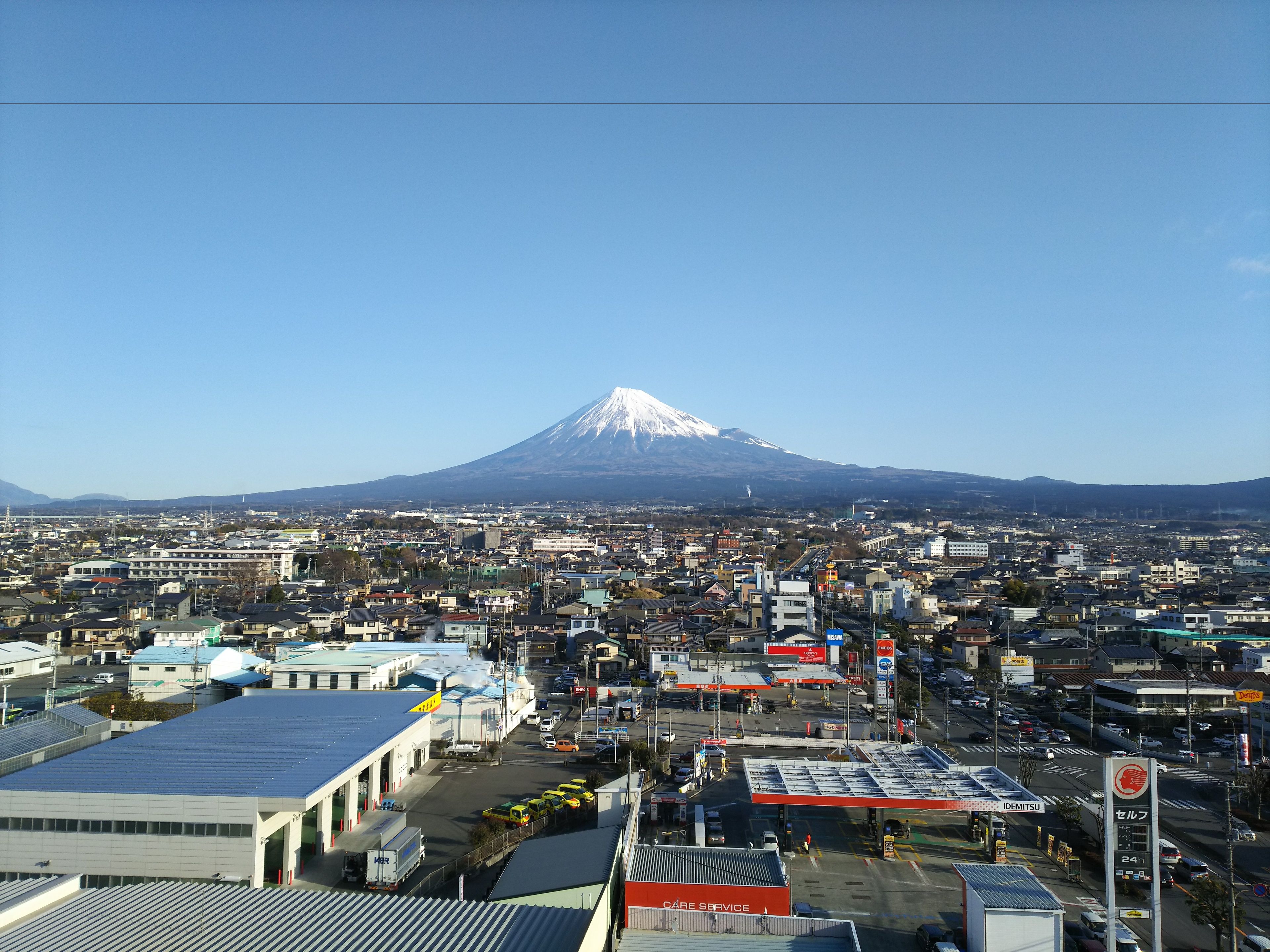 Un paisaje urbano con una montaña destacada al fondo.