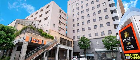 A multi-story hotel with a prominent sign for APA HOTEL.