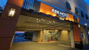 Ingången till APA Hotel har en modern design och inkluderar en tydlig skylt samt ett överbyggt entréområde.