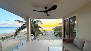 A balcony with a view of the beach, a ceiling fan, and a sofa. - Sabaii Bay Resort (Ko Pha-ngan)