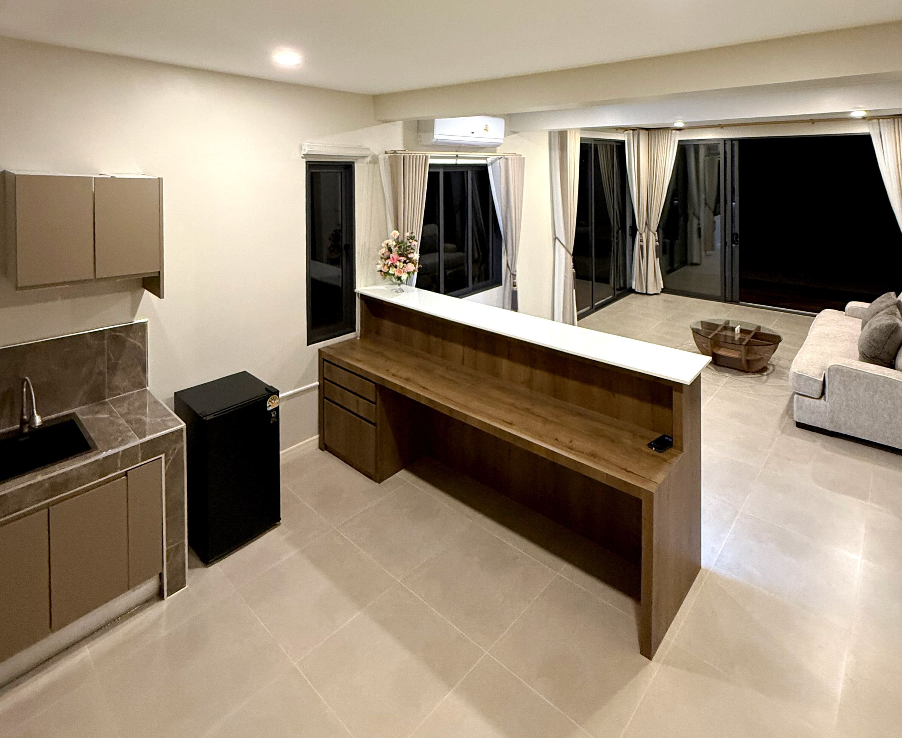 A modern kitchen with a wooden countertop, a built-in sink, and a black trash bin.
