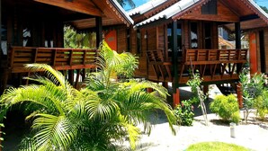Two wooden cabins with balconies, surrounded by lush greenery. - Sabaii Bay Resort (Ko Pha-ngan)