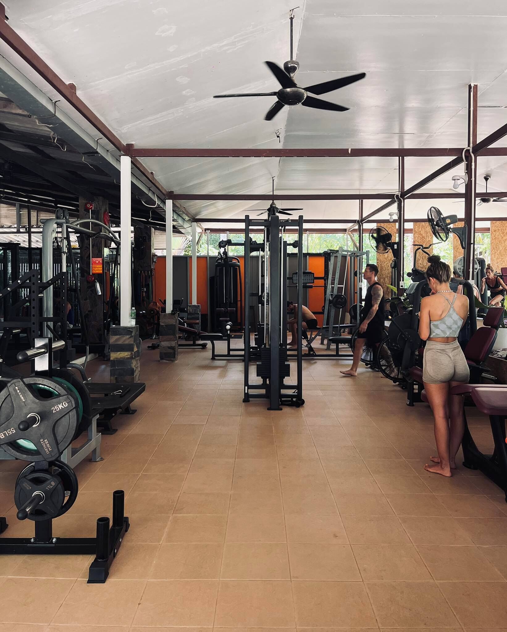 A gym with various exercise equipment, including weight machines and free weights.