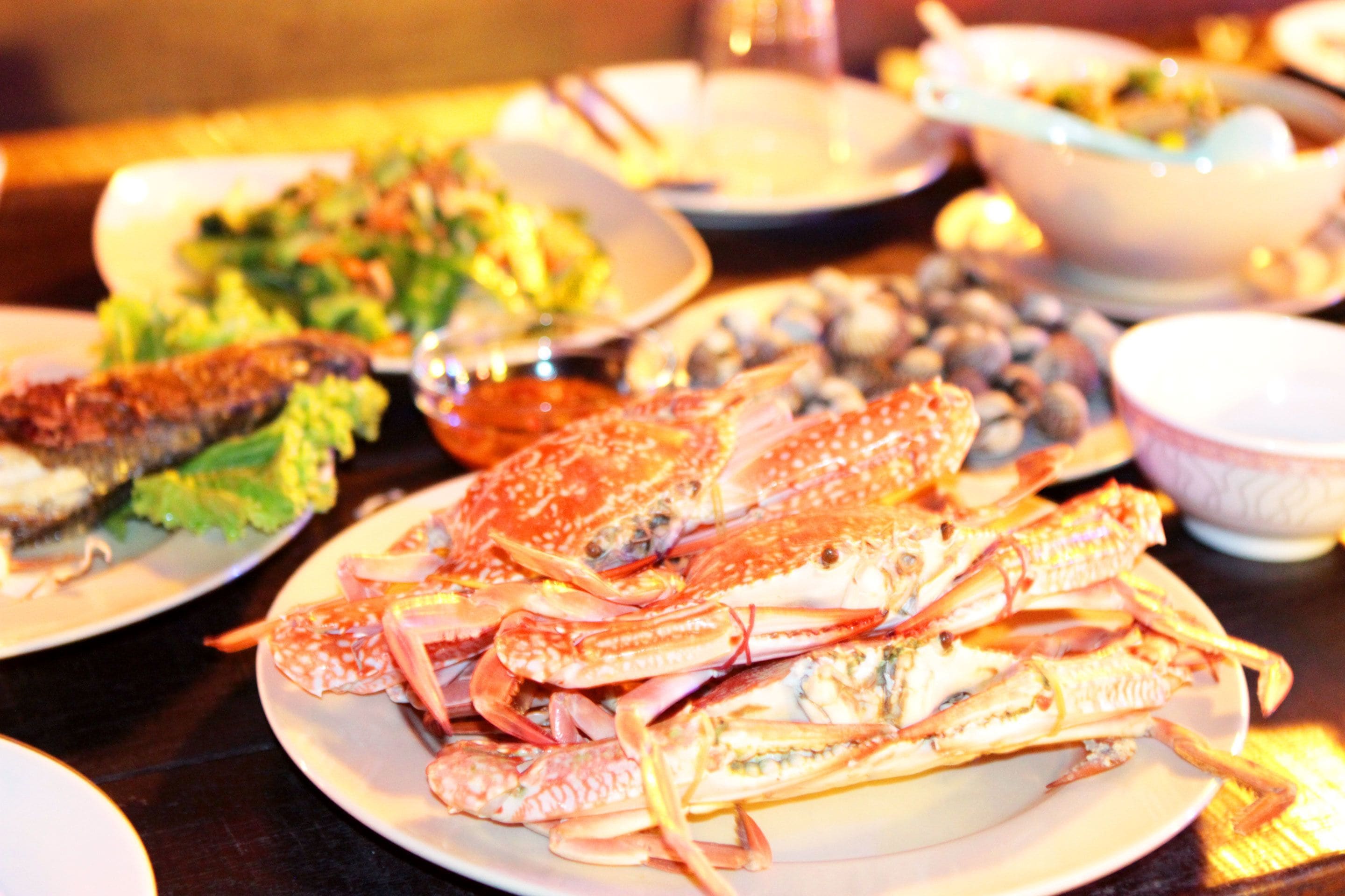 A table with plates of seafood, including crab legs, and other dishes.