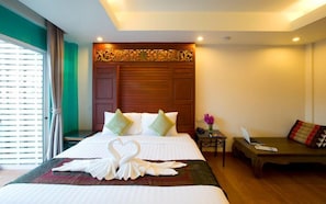 Habitación de hotel con cama, escritorio y un pequeño rincón de descanso.