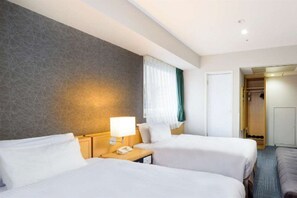 A hotel room with two beds, a bedside table with a lamp, a telephone, and a wardrobe. - Shin Osaka Hotel (Osaka)