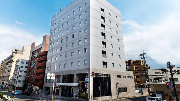 A modern multi-story building with a flat facade, numerous windows, and a visible entrance. - Shin Osaka Hotel (Osaka)
