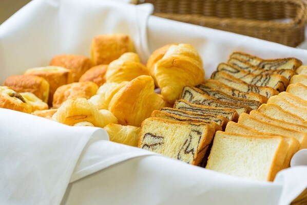 A variety of pastries including croissants and a marble cake, arranged in a white basket. - Shin Osaka Hotel (Osaka)