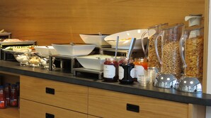 A buffet setup with various food containers and condiments. - Hotel Neuthor (Ulm)