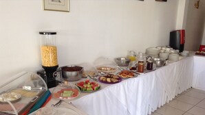 A buffet table with various food items and condiments. - Galaxy Hotel (Ierapetra)