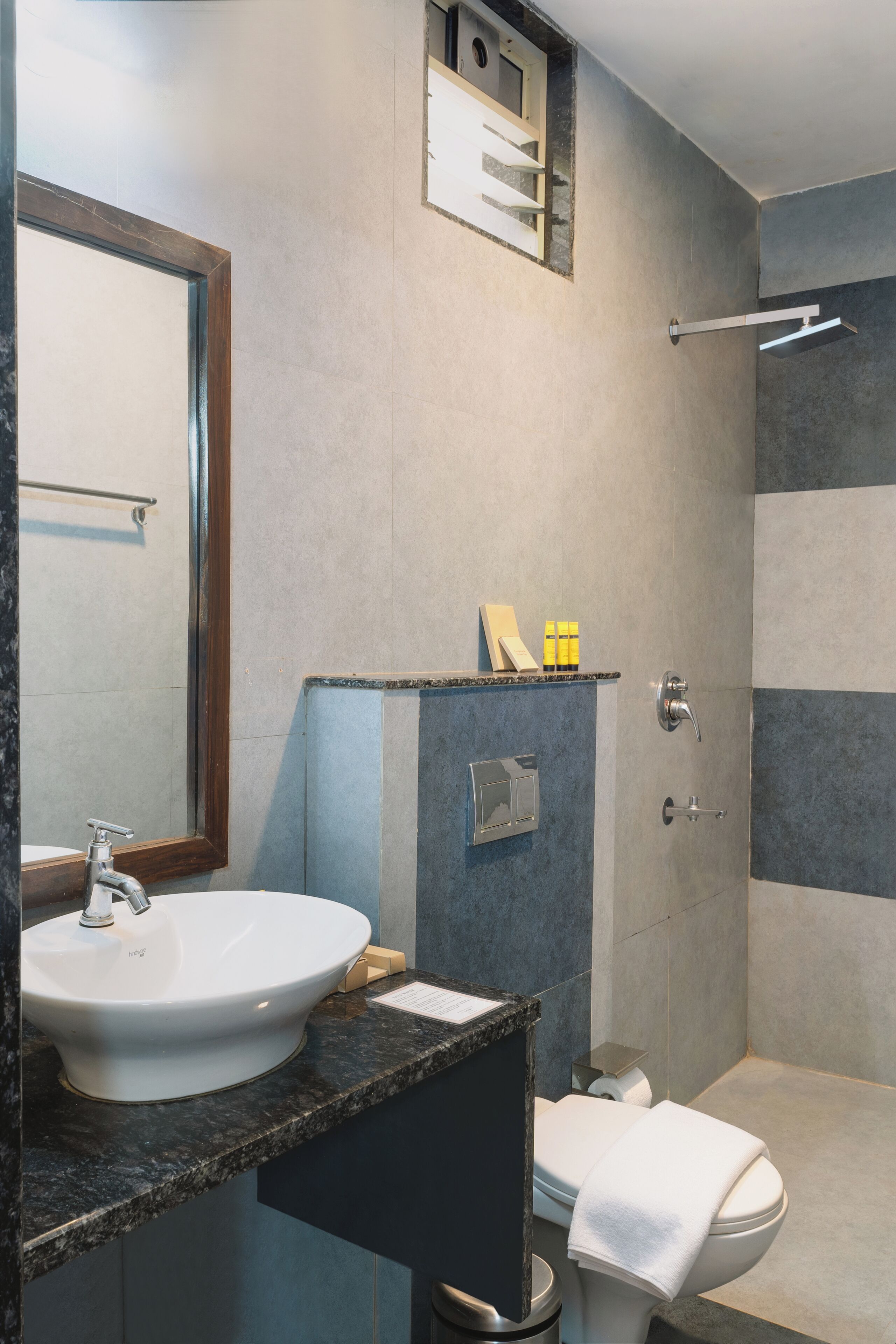 A bathroom with a sink, mirror, toilet, and shower.