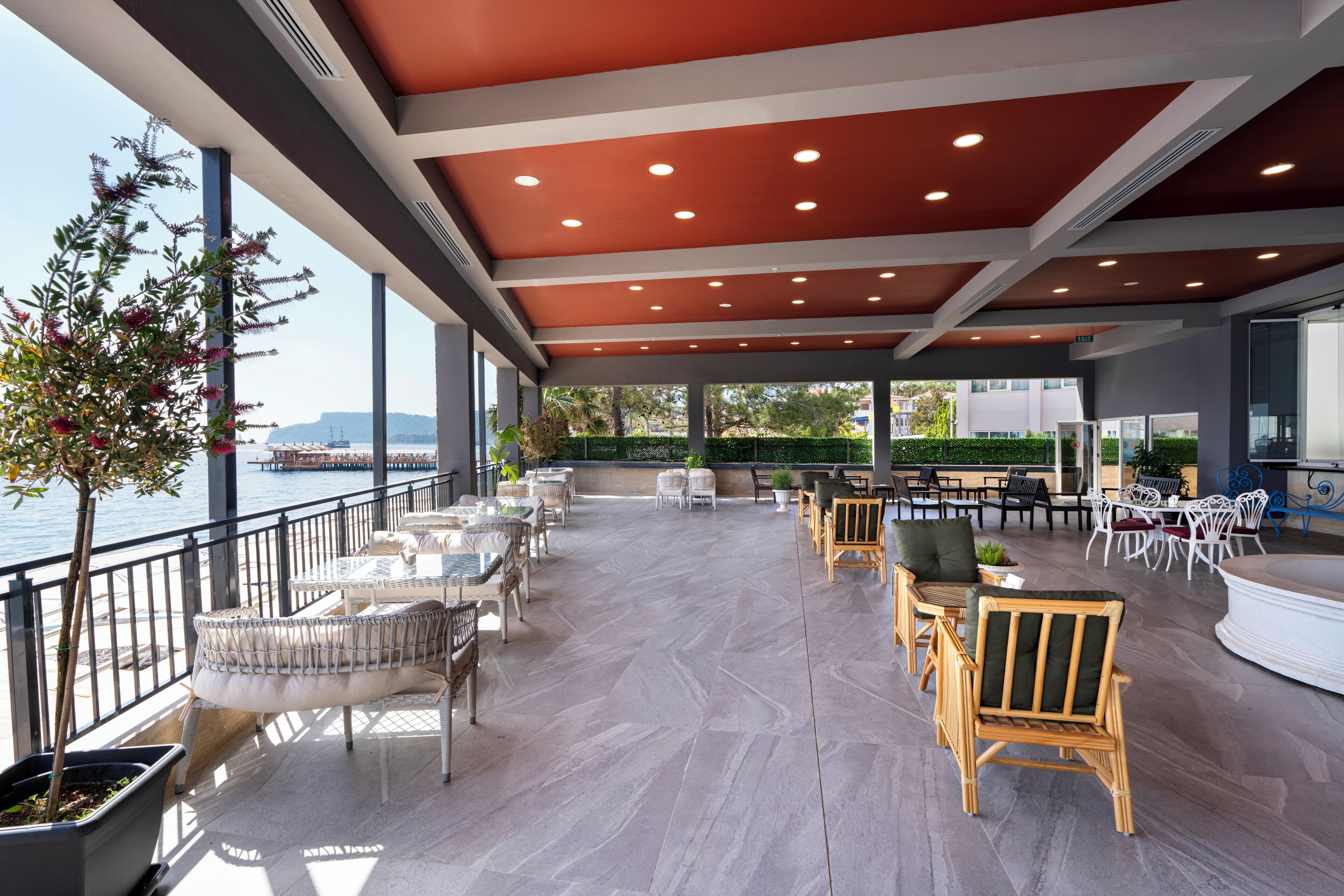 An outdoor patio with seating, a view of the water, and a modern ceiling design.