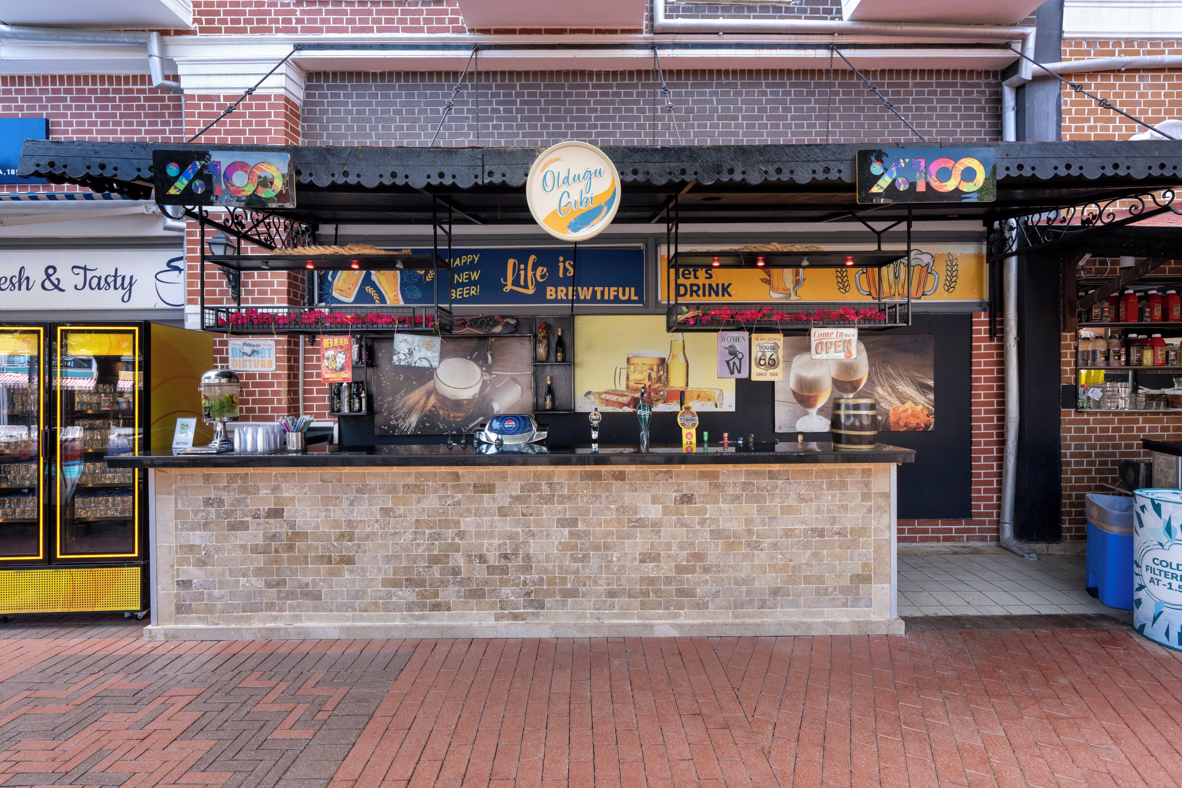 Een openluchtbalkon met een metselstenen toonbank, een biertappunt en een bordje met de tekst 'Oldgu Club'.