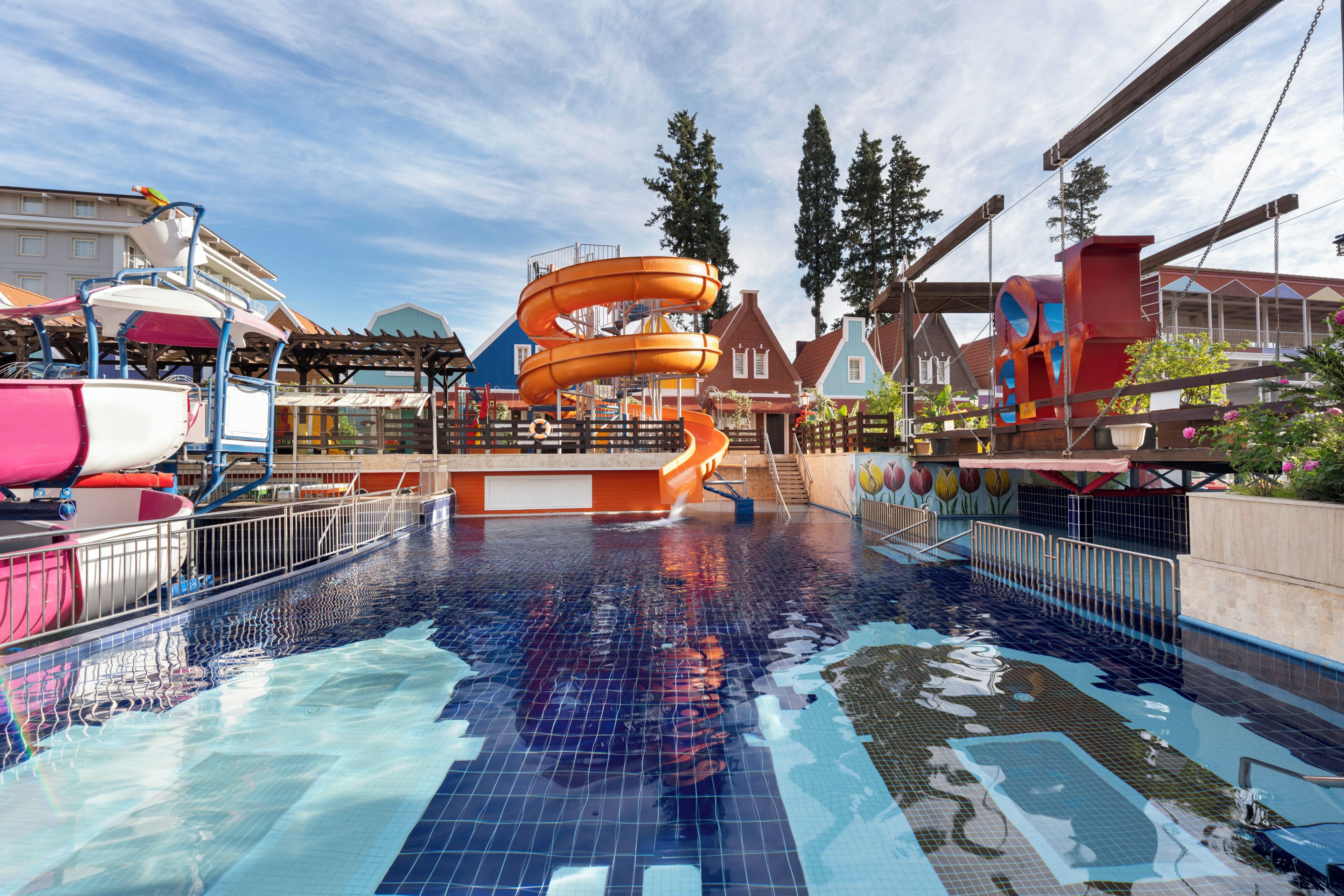 Parque acuático con piscina, toboganes y una zona cubierta.