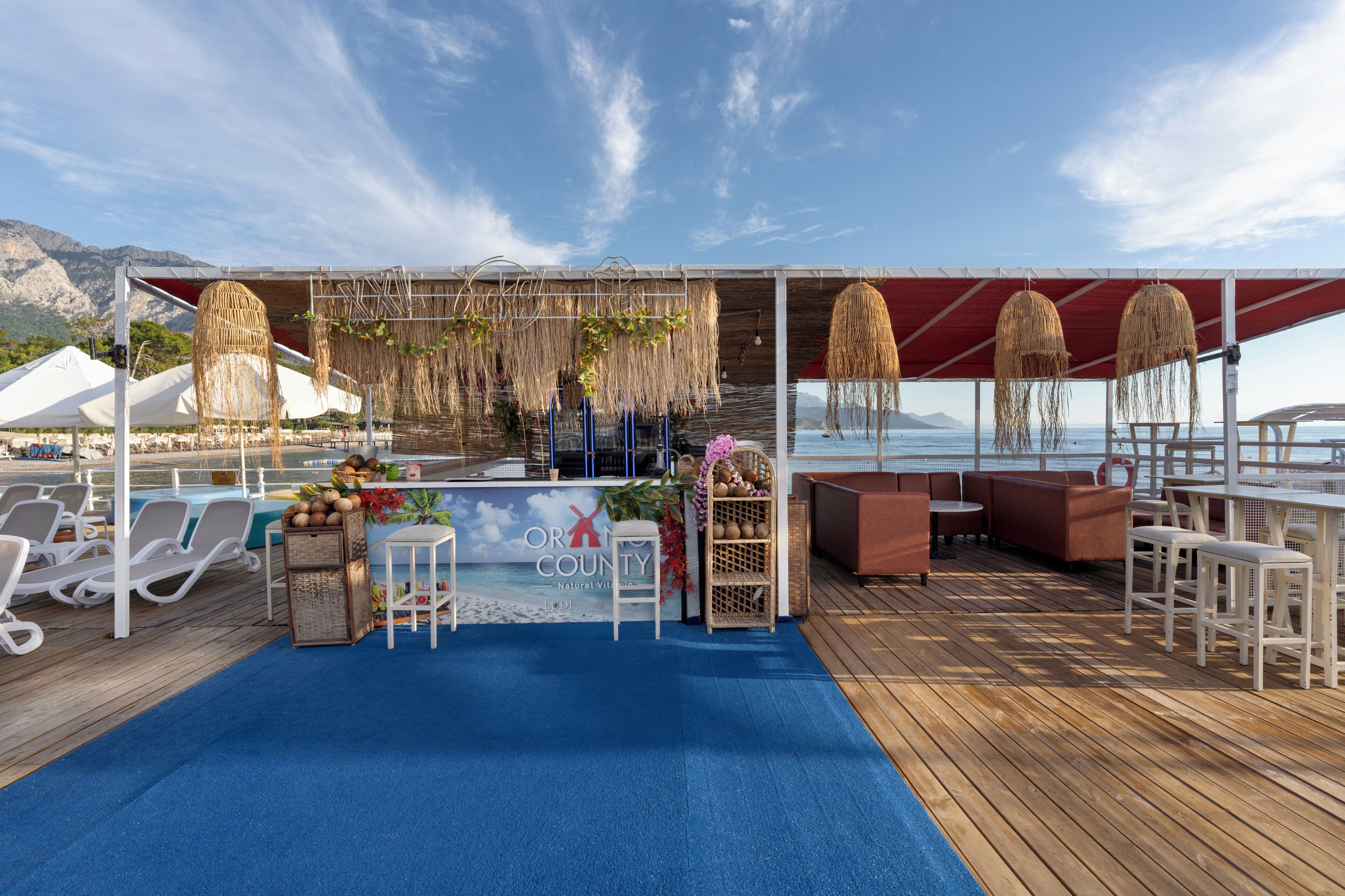 Terraza con sillones, zona de bar y vista al mar.