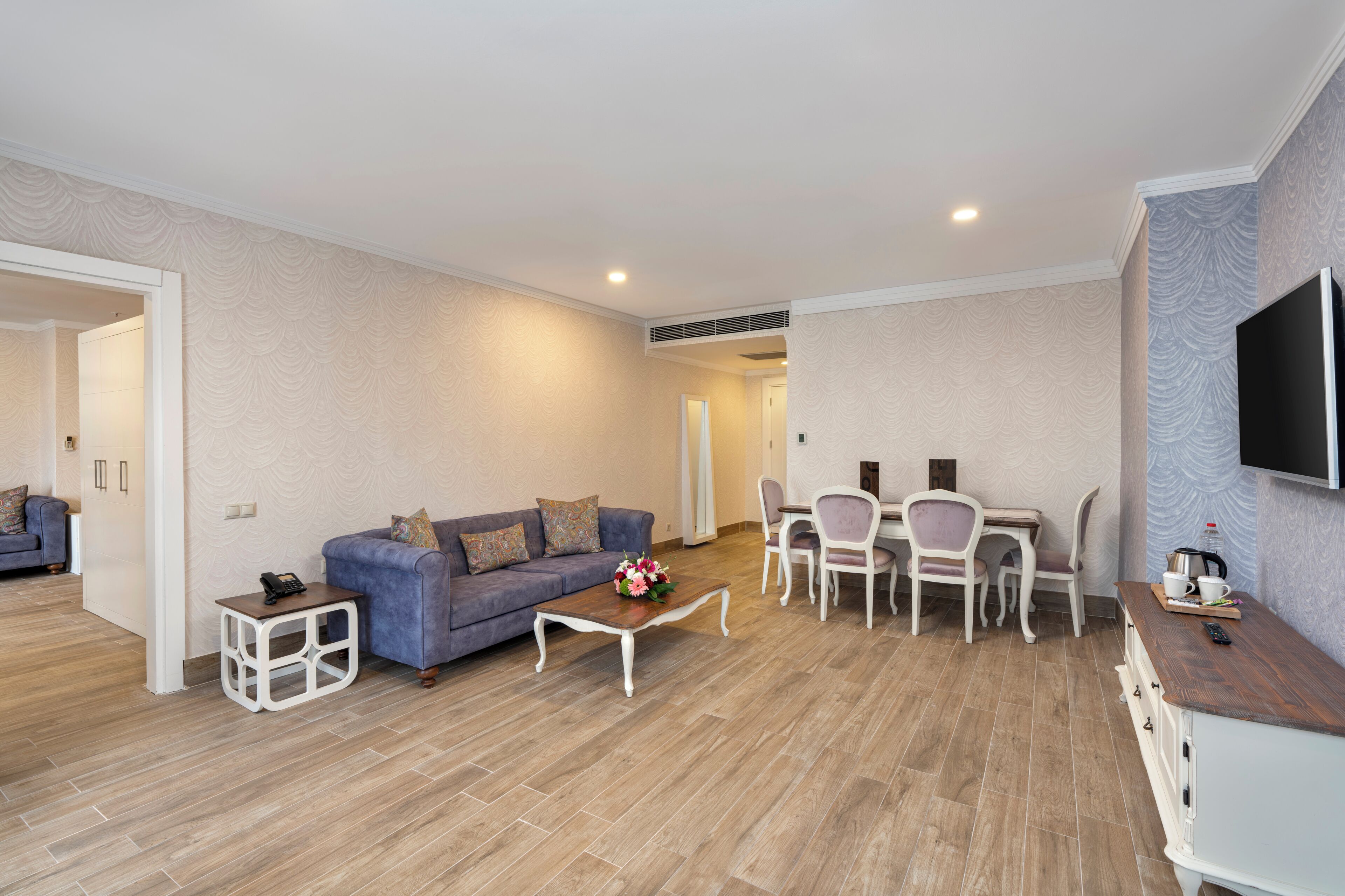 A modern living room with a sofa, coffee table, and dining area.