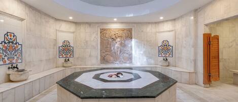 A luxurious bathroom with a central marble sink, decorative tiles, and a large mural on the wall.