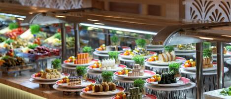 A buffet with various food items displayed on plates and trays.