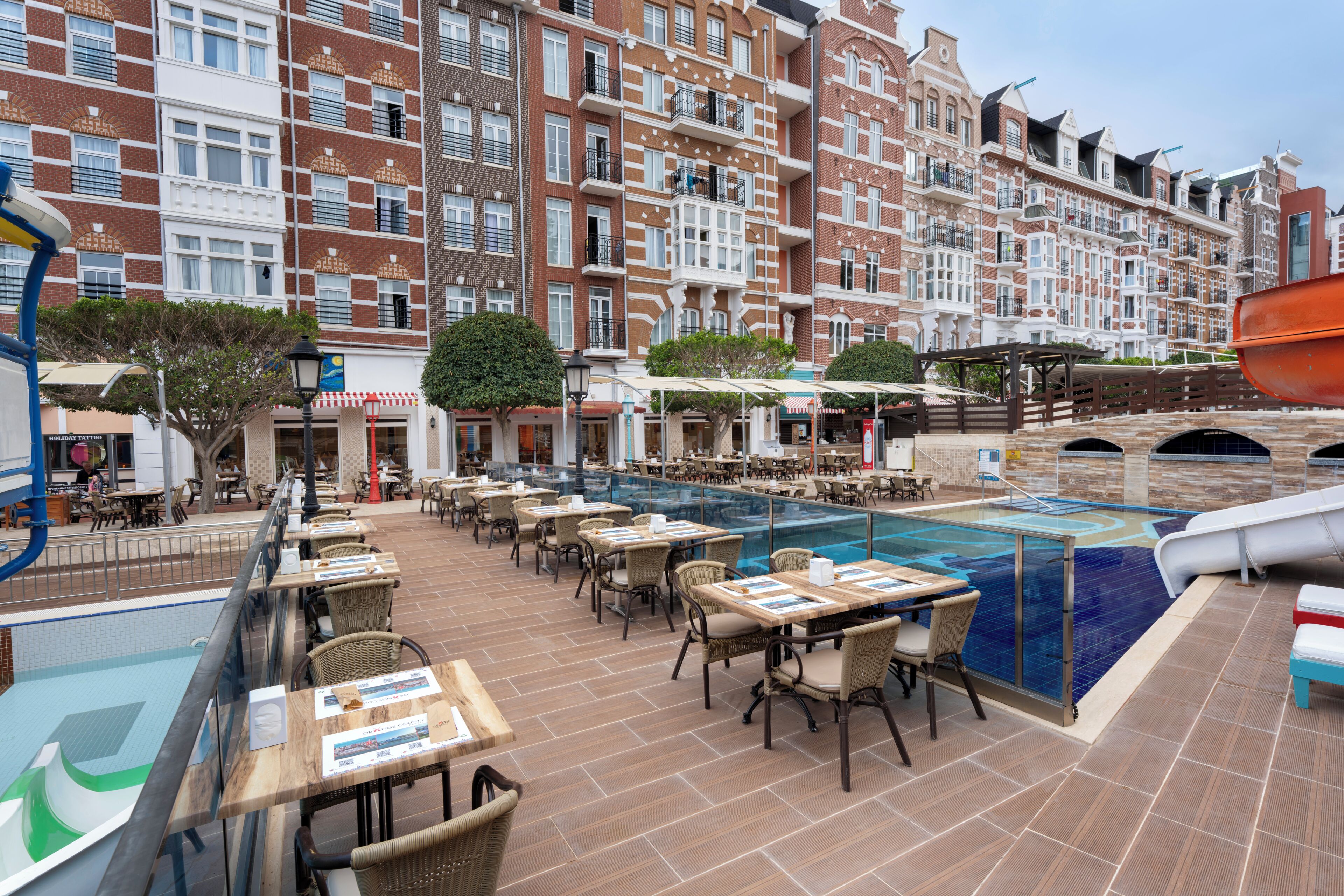 A rooftop pool area with outdoor seating and a view of a historic building in the background.