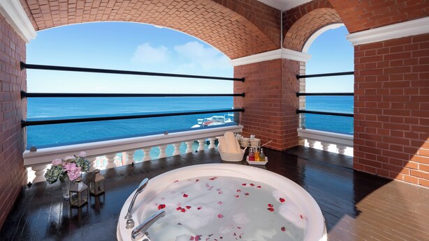 A balcony with a view of the sea, a bathtub with rose petals, and a wicker basket with toiletries. - Orange County Kemer (Kemer)