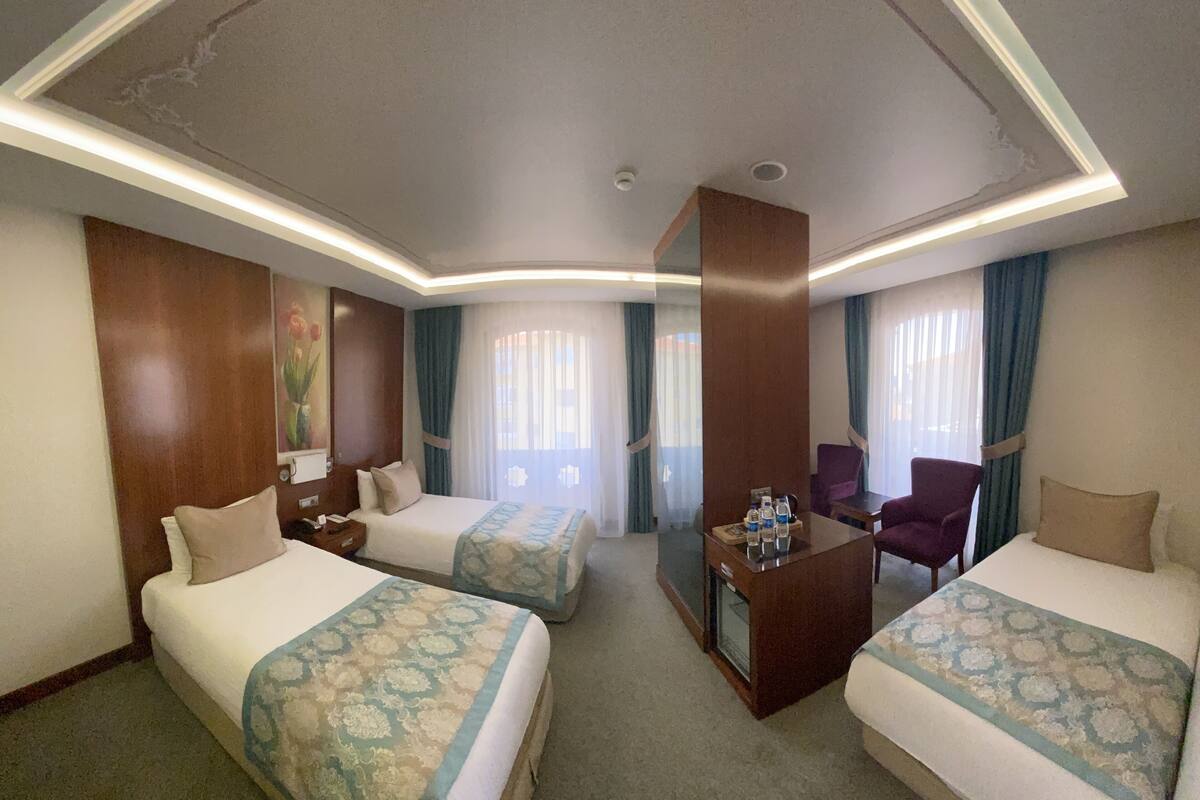 A hotel room with two beds, a desk, and a chair.