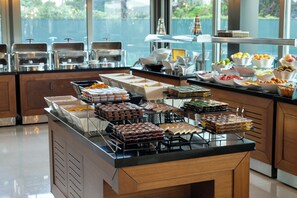 A buffet with various food items and a view of the outdoors. - Miracle Istanbul Asia Airport Hotel & Spa (Istanbul)