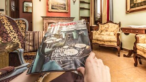 Una persona sosteniendo un libro titulado 'Hotel Design' con imágenes de interiores de hoteles.