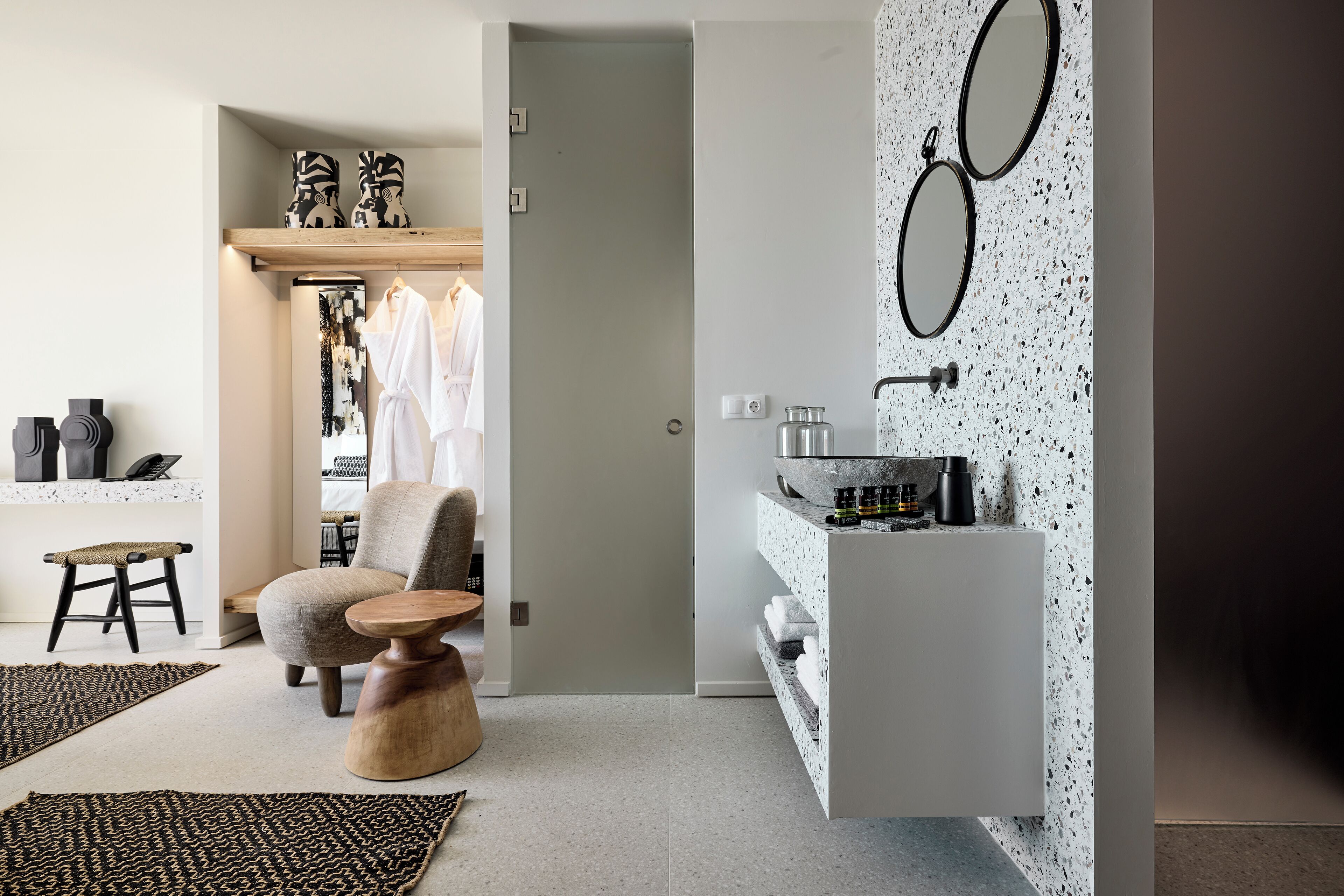 A modern bathroom with a freestanding sink, two mirrors, and a towel rack.