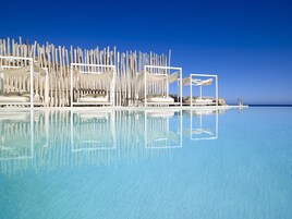 Una piscina al aire libre, camas de piscina gratis, sombrillas