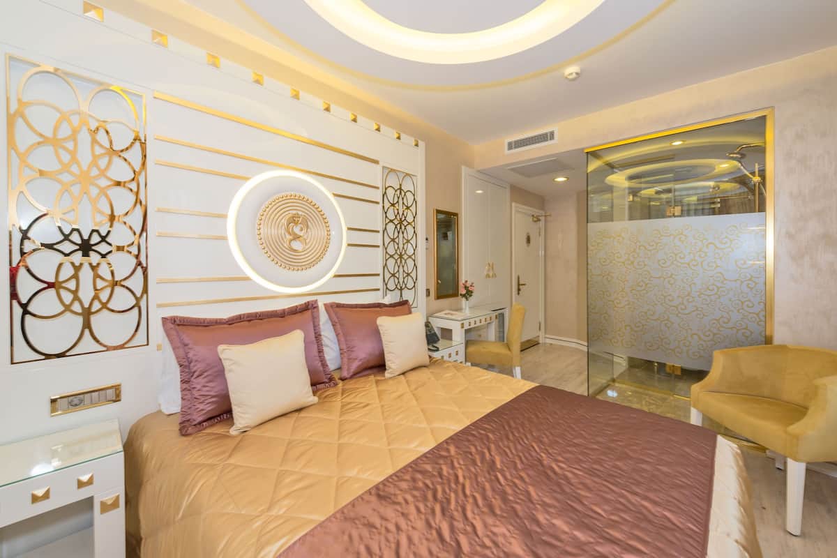A modern bedroom with a large bed, a desk, and a chair.