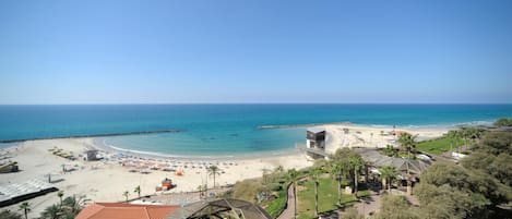 Rannalla, aurinkotuoleja, rantapyyhkeitä