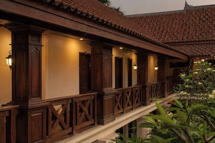 Un edificio de estilo arquitectónico tradicional, con un balcón de barandillas y columnas de madera.