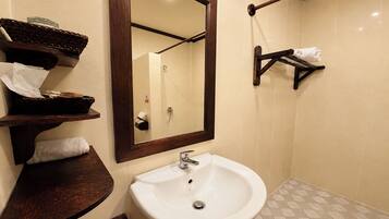 A bathroom with a white sink, a mirror, and a towel rack.