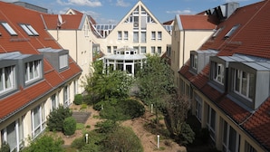 A courtyard with a central building featuring a triangular roof and multiple windows. - Comfor Hotel Ulm City (Ulm)